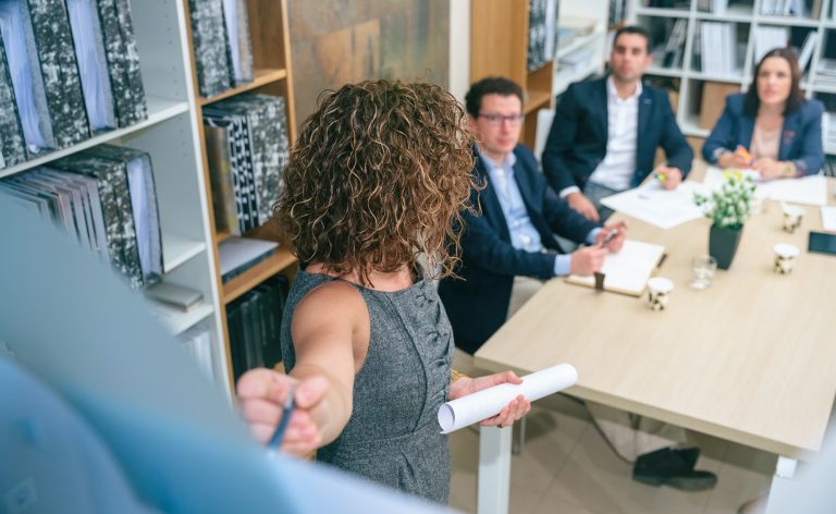 female-coach-explaining-project-to-business-team-in-headquarters